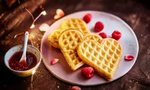 Gaufres en forme de cœur, parfaites pour une recette gaufre moelleuse, servies avec de la confiture de framboise et des fruits rouges.