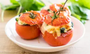 Trois tomates farcies au fromage et aux herbes, prêtes à être dégustées. Une recette simple et savoureuse.