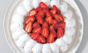 Délicieuse recette avec fraises fraîches facile : meringue aérienne et fruits rouges sur une assiette décorative.