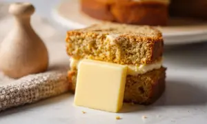 Un délicieux gâteau au café, garni de crème et d'une tranche de beurre, prêt à être dégusté.