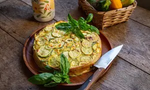 Un délicieux cake à la courgette, garni de basilic frais, prêt à être découpé.