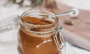 Un pot de praliné noisette maison, prêt à être dégusté. Une recette simple pour un délice gourmand.