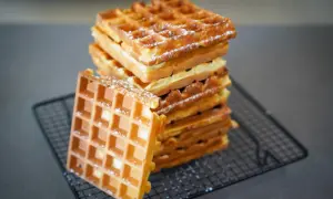 Pile de gaufres dorées et croustillantes, saupoudrées de sucre glace. La recette parfaite pour un petit-déjeuner gourmand.