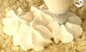 Application d'une crème pâtissière pour tarte à la poche à douille, créant de jolies rosaces sur une base de gâteau.