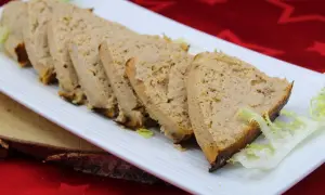 Tranches de pain de thon crème fraîche, garnies de salade, sur une assiette blanche.