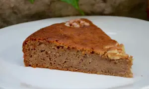 Tranche de gâteau aux noix moelleux, garnie d'une noix entière. Parfait pour une recette facile et gourmande.