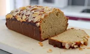 Un délicieux gâteau aux amandes effilées, coupé en part, promettant le meilleur gâteau aux amandes.