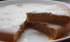 Un délicieux gâteau à la crème de marron, saupoudré de sucre glace, avec une part coupée pour révéler sa texture moelleuse.