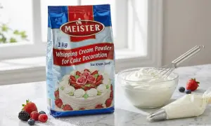 Un paquet de poudre pour crème fouettée Meister, prêt à être transformé en délicieuse crème montée vanille pour décorer des gâteaux. Des fruits frais et une poche à douille complètent la scène.