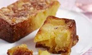 Un gâteau aux pommes moelleux et ultra rapide, doré et appétissant, servi sur une assiette blanche.