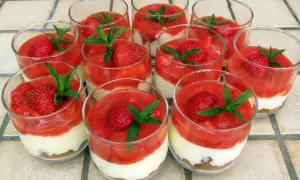 Douze verrines de tiramisu fraise spéculoos, garnies de fruits rouges et de menthe fraîche.