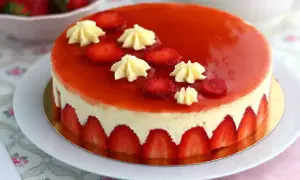Un magnifique fraisier, parfait pour une recette gourmande. La crème onctueuse est bordée de fraises fraîches, le tout nappé d'un glaçage rouge éclatant.