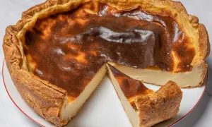 Un flan pâtissier doré, avec une croûte croustillante et une garniture crémeuse, une part coupée révèle sa texture onctueuse.