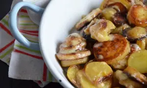 Un plat de truffade de l'Aubrac, pommes de terre fondantes et crémeuses, servi dans un bol blanc.