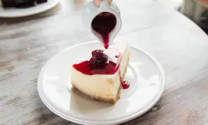 Un délicieux cheesecake garni de coulis de fruits rouges, un dessert rapide sans cuisson parfait pour se régaler.