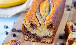 Un délicieux banana bread aux pépites de chocolat, garni de bananes entières sur le dessus.