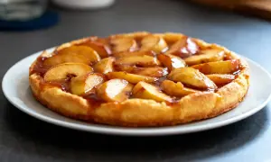 Une tarte tatin aux pommes caramélisées, dorée et appétissante, prête à être dégustée.