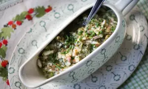 Sauce ravigote fraîche et acidulée, garnie de ciboulette ciselée, dans un saucier décoré.