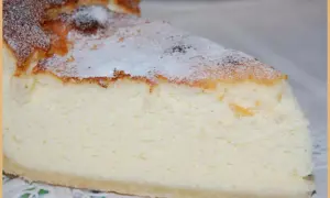 Tranche de tarte au fromage blanc, légère et aérienne, saupoudrée de sucre glace. Un délice crémeux à savourer.