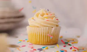 Un cupcake vanille avec glaçage crémeux et vermicelles colorés, parfait pour une recette de cupcake facile et festive.