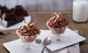 Deux coupes de mousse au chocolat sans oeuf, garnies de bâtonnets de chocolat blanc et brun.