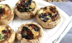 Champignons farcis au four, garniture aux olives noires et tomates séchées, fromage fondant. Une recette simple et savoureuse.