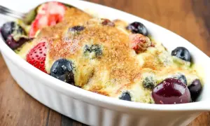 Un délicieux sabayon aux fruits rouges, fraises et myrtilles, gratiné et prêt à être dégusté.