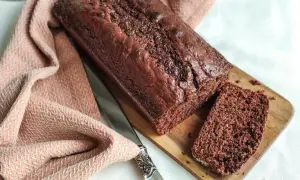 Un délicieux gâteau yaourt chocolat, moelleux et gourmand, prêt à être dégusté. Une tranche est déjà coupée.