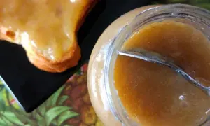 Un pot de confiture rhubarbe banane et une tartine généreusement garnie. Une gourmandise maison prête à être dégustée.