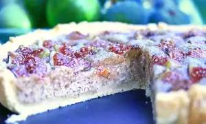 Une délicieuse tarte aux figues, avec sa pâte dorée et sa garniture généreuse de fruits violets et rouges.
