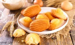 Assiette de madeleines dorées, prêtes à être dégustées. Une recette simple pour un goûter parfait.