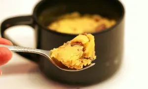 Une cuillère de mug cake cookie, moelleux et gourmand, prêt à être dégusté.