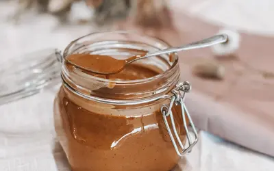 Un pot de praliné noisette maison, prêt à être dégusté. Une recette simple pour un délice gourmand.