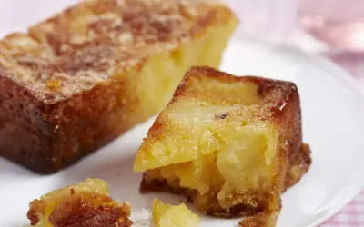 Un gâteau aux pommes moelleux et ultra rapide, doré et appétissant, servi sur une assiette blanche.