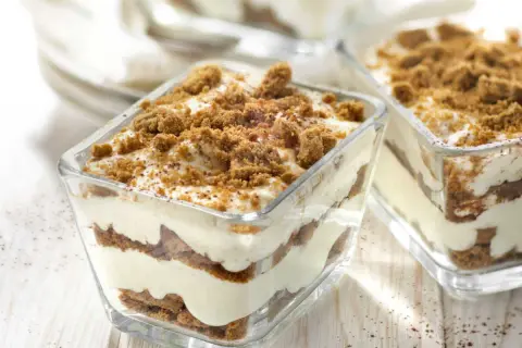 Délicieux tiramisu speculoos en verrines, superposant crème onctueuse et biscuits émiettés, le tout saupoudré de miettes croustillantes.