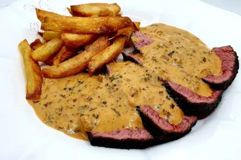 Tranches de bœuf saignant nappées d'une sauce crémeuse, accompagnées de frites dorées. Un délice avec cette sauce viande rouge.