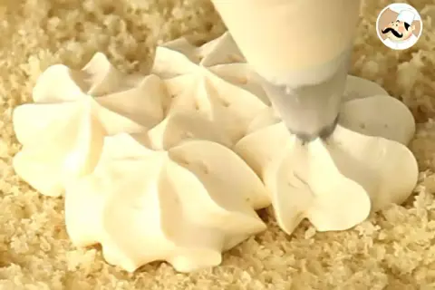 Application d'une crème pâtissière pour tarte à la poche à douille, créant de jolies rosaces sur une base de gâteau.