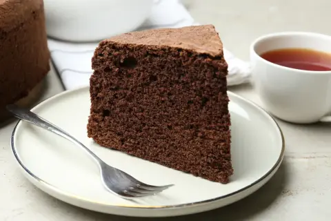Une part de moelleux gâteau au chocolat, prête à être dégustée avec une tasse de thé. Une recette simple pour un plaisir gourmand.