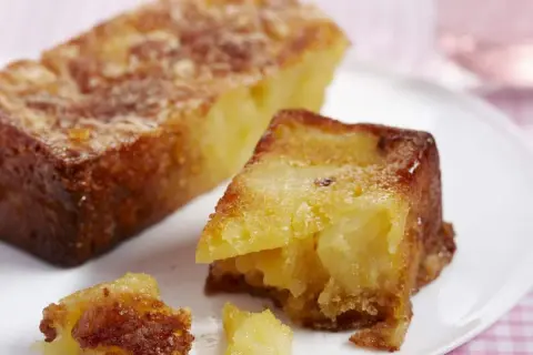 Un gâteau aux pommes moelleux et ultra rapide, doré et appétissant, servi sur une assiette blanche.