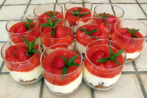Douze verrines de tiramisu fraise spéculoos, garnies de fruits rouges et de menthe fraîche.