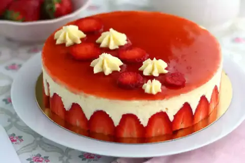 Un magnifique fraisier, parfait pour une recette gourmande. La crème onctueuse est bordée de fraises fraîches, le tout nappé d'un glaçage rouge éclatant.