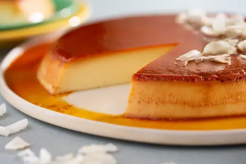 Un flan aux œufs onctueux, nappé de caramel doré et garni de copeaux de noix de coco. Un délice à savourer.