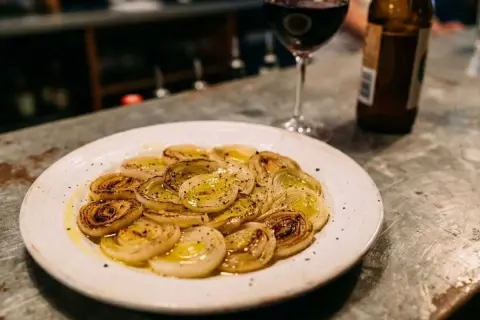Poireaux vinaigrette, tendres et caramélisés, accompagnés d'un verre de vin rouge et d'une bière. Un délice simple.