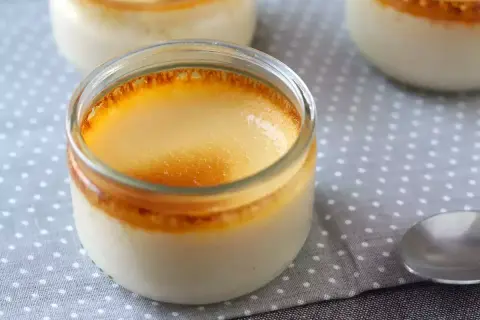 Crème aux œufs grand-mère dans des pots en verre, avec une croûte caramélisée dorée. Un délice réconfortant.