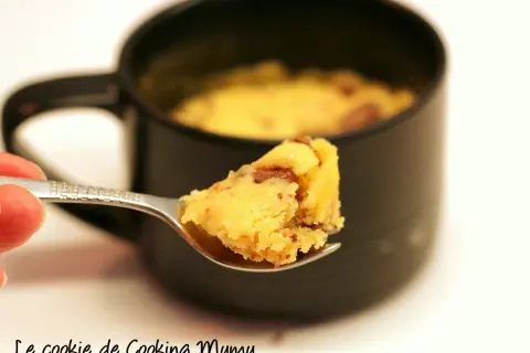 Une cuillère de mug cake cookie, moelleux et gourmand, prêt à être dégusté.