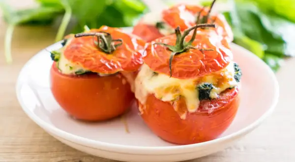 Trois tomates farcies au fromage et aux herbes, prêtes à être dégustées. Une recette simple et savoureuse.