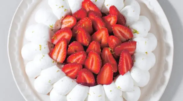 Délicieuse recette avec fraises fraîches facile : meringue aérienne et fruits rouges sur une assiette décorative.