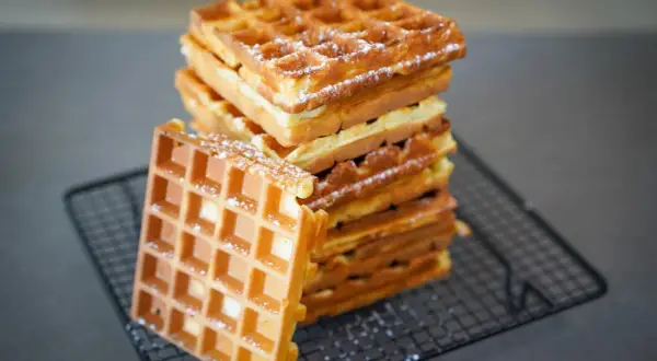 Pile de gaufres dorées et croustillantes, saupoudrées de sucre glace. La recette parfaite pour un petit-déjeuner gourmand.