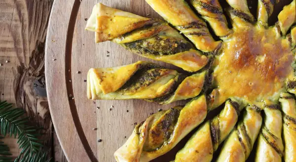 Tarte soleil dorée, garnie d'une farce verte, prête à être dégustée.