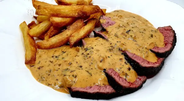 Tranches de bœuf saignant nappées d'une sauce crémeuse, accompagnées de frites dorées. Un délice avec cette sauce viande rouge.